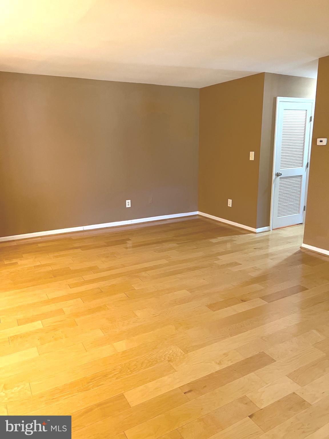 9633 White Acre Road, Unit B2 Columbia, MD 21045 - Photo 7 of 22 a view of an empty room with wooden floor