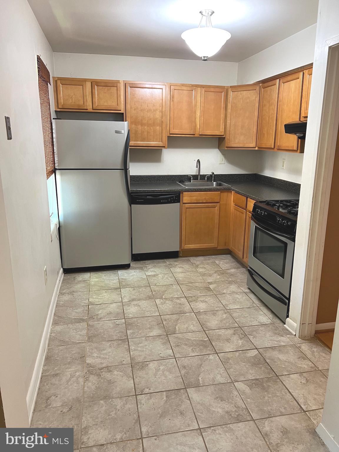 9633 White Acre Road, Unit B2 Columbia, MD 21045 - Photo 8 of 22 a kitchen with granite countertop a refrigerator and a stove top oven