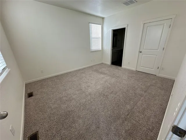 an empty room with windows and closet