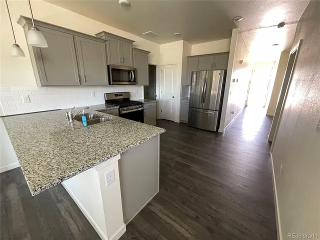 a kitchen with stainless steel appliances granite countertop a refrigerator microwave and stove