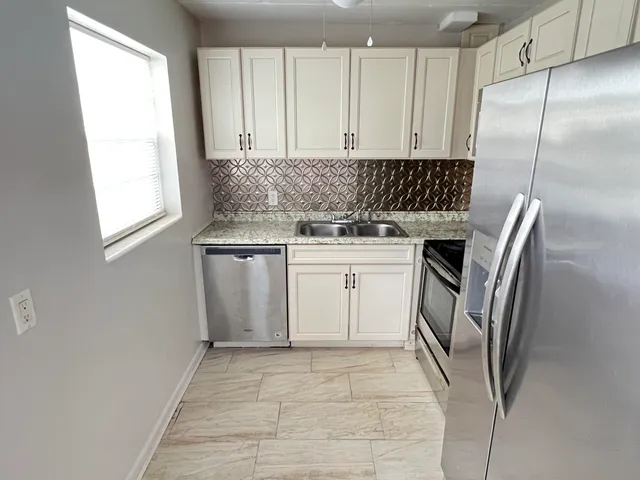 a kitchen with granite countertop a sink and cabinets