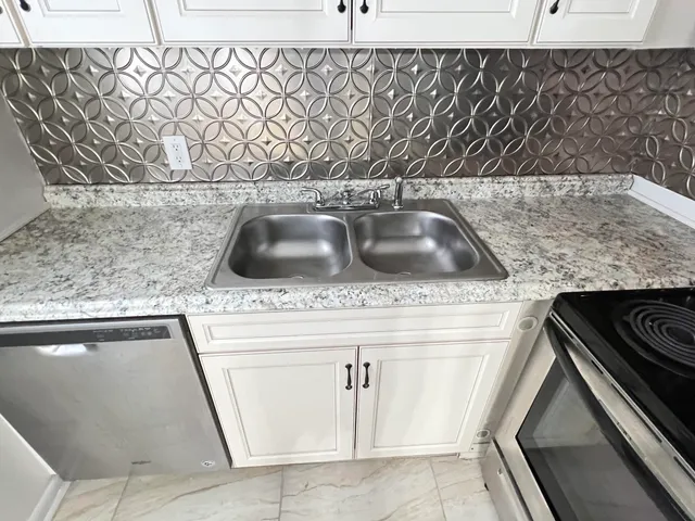 a kitchen with white cabinets and white appliances