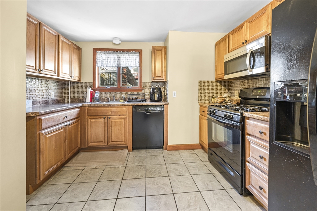 50 Temple Street, Unit 50 Somerville, MA 02145 - Photo 13 of 41 a kitchen with stainless steel appliances granite countertop a stove a sink dishwasher and a refrigerator