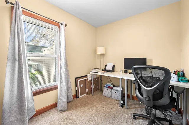 a view of a workspace with furniture and a window