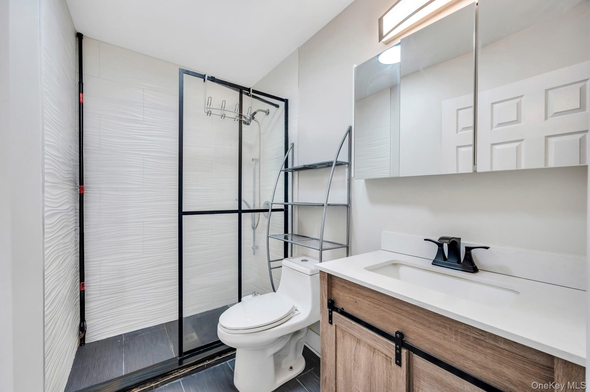 15 Drake Avenue Bellport, NY 11713 - Photo 14 of 20 a bathroom with a sink a toilet and shower