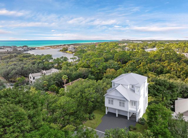 an aerial view of a house with a yard and lake view