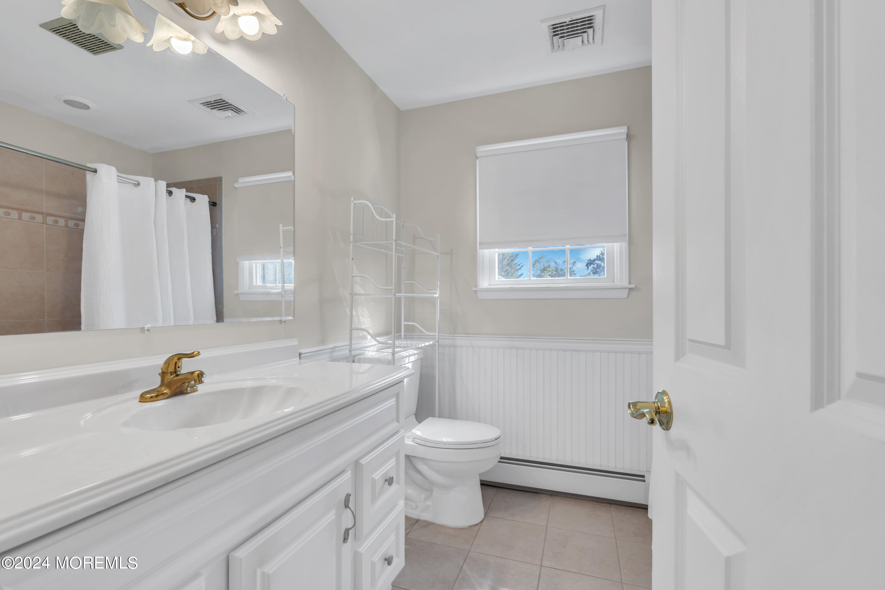 807 Prospect Avenue Spring Lake Heights, NJ 07762 - Photo 19 of 27 a bathroom with a sink a toilet and a mirror