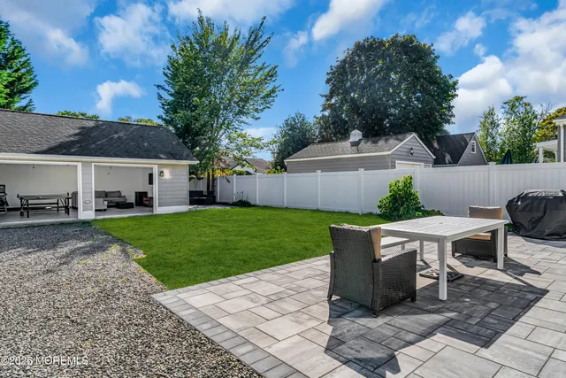 a view of a patio with table and chairs potted plants and large tree