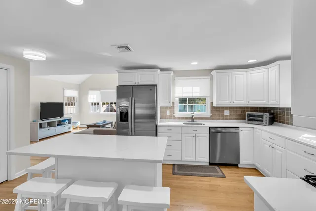 a kitchen with a sink a counter top space stainless steel appliances and cabinets
