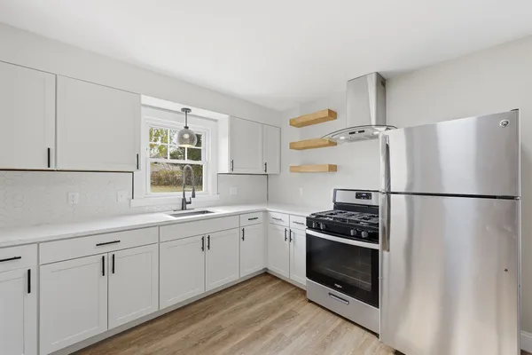 a kitchen with white cabinets and white appliances