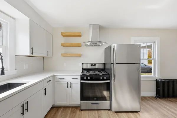 a kitchen with cabinets stainless steel appliances and wooden floor
