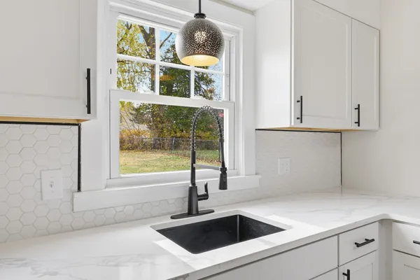 a kitchen with stainless steel appliances granite countertop a sink and a window