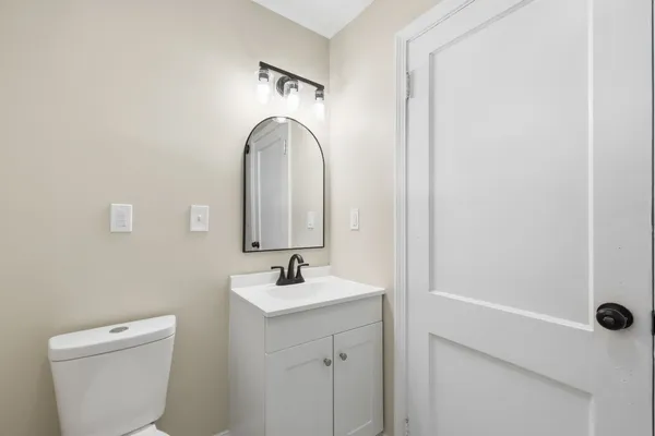 a bathroom with a sink a toilet and a mirror