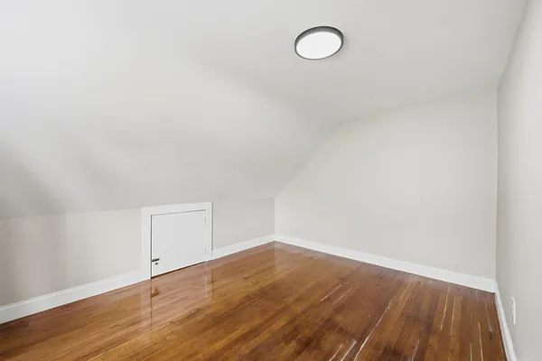 a view of a room with wooden floor and white walls