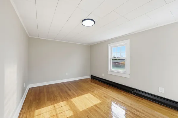 a view of a room with wooden floor and window