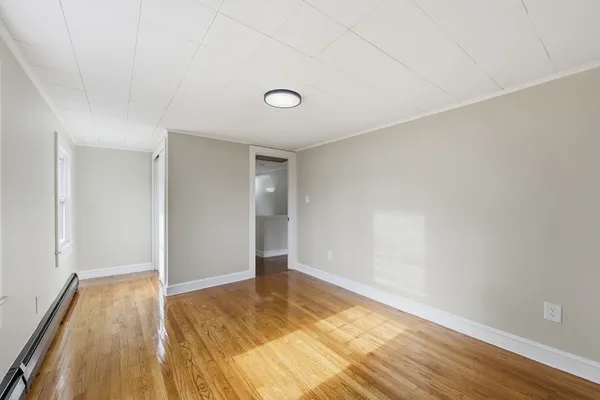 a view of an empty room and wooden floor
