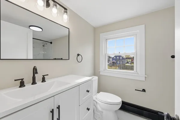 a bathroom with a toilet sink and mirror