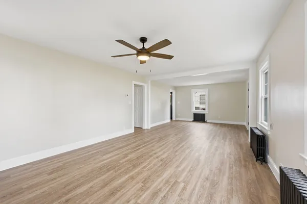 a view of a livingroom with a ceiling fan and wooden floor