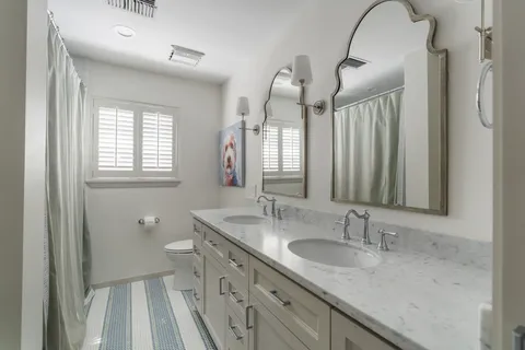 a bathroom with a sink vanity granite and a mirror