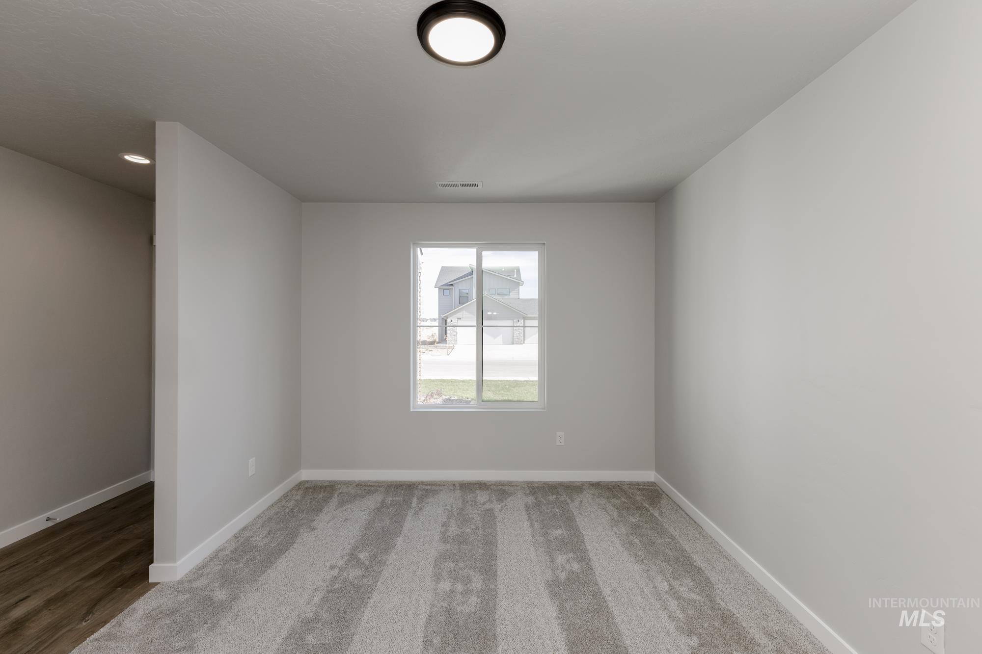 12853 Decatur Street Nampa, ID 83651 - Photo 12 of 24 Neutral-toned room featuring a single window, light gray carpeting, and a flush-mount ceiling light