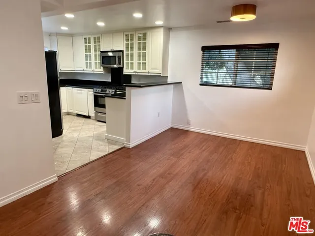 a kitchen with stainless steel appliances granite countertop a stove and a wooden floors