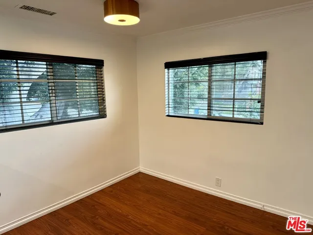 a view of a room with wooden floor and a window