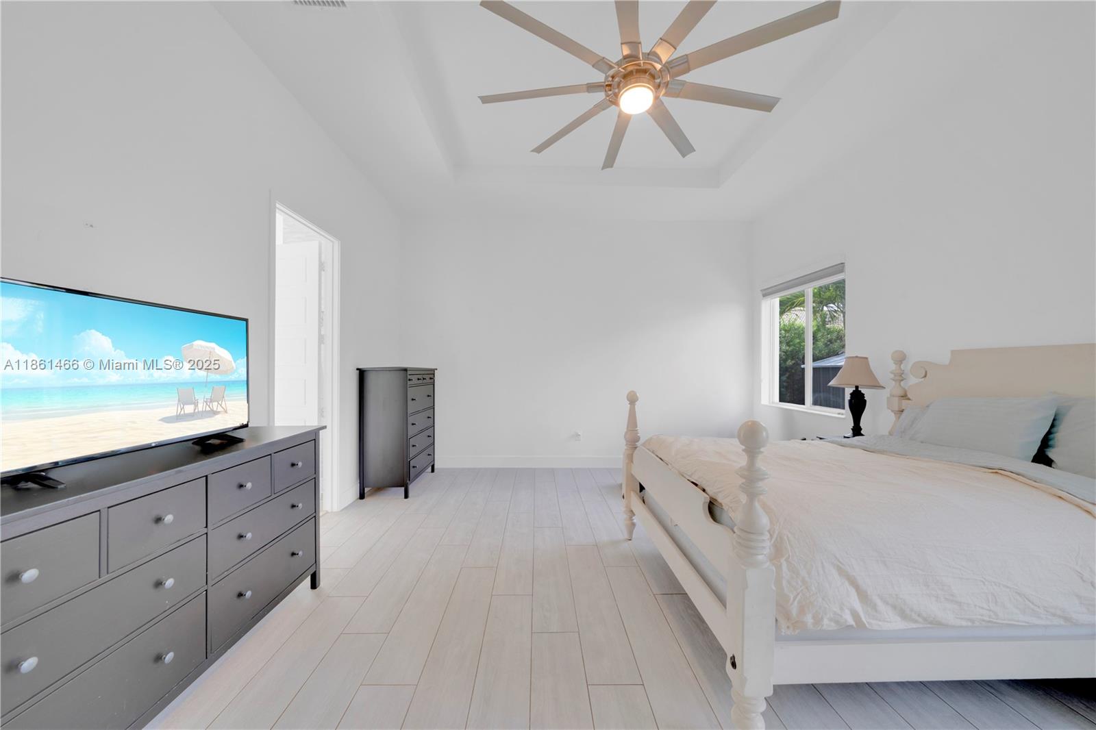 15012 Southwest 177th Terrace Miami, FL 33187 - Photo 14 of 16 a spacious bedroom with a large bed and a flat screen tv