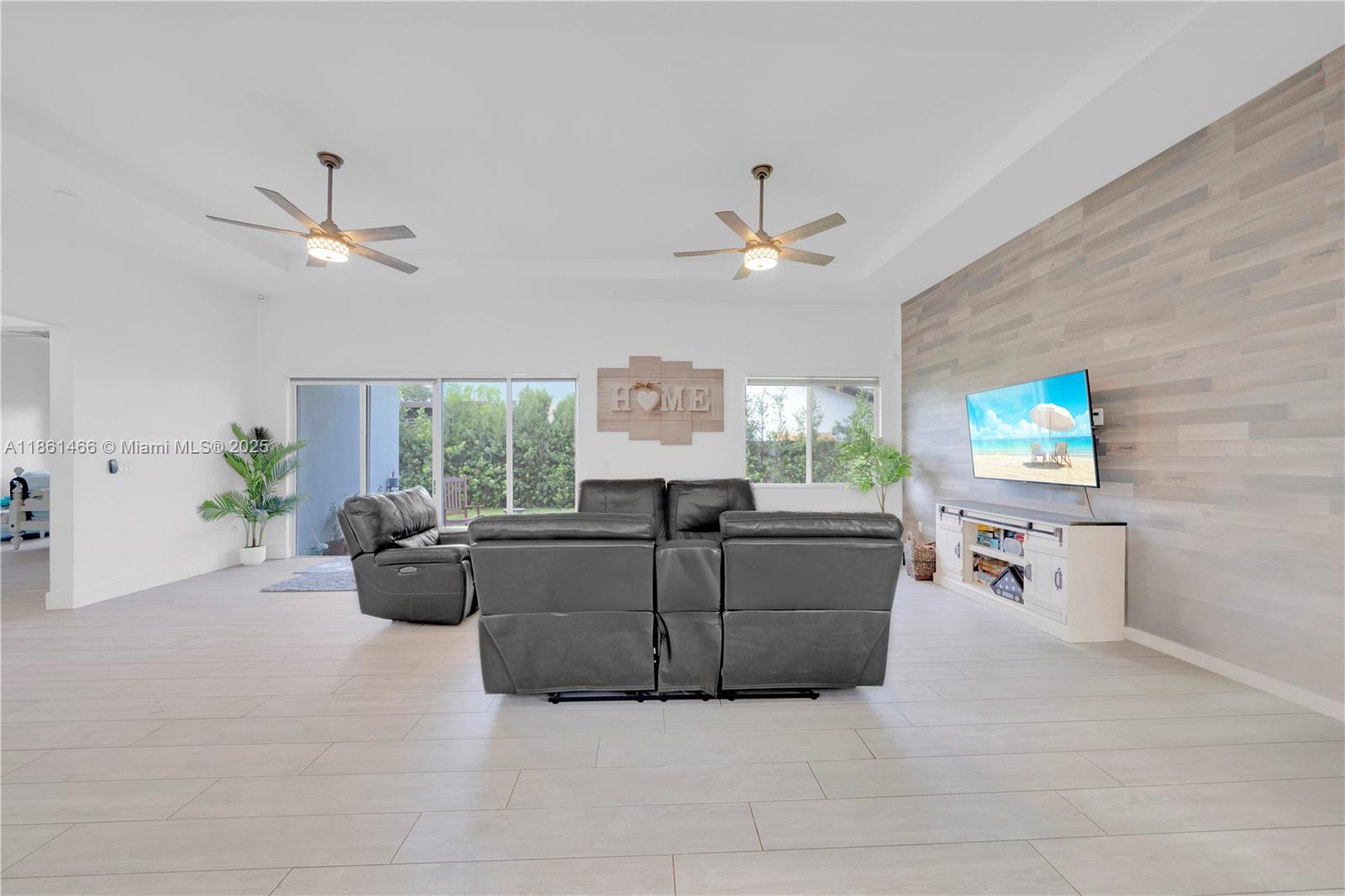 15012 Southwest 177th Terrace Miami, FL 33187 - Photo 6 of 16 a living room with furniture a fireplace and a flat screen tv