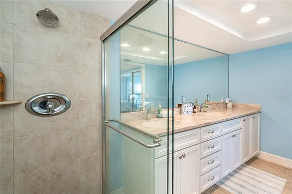 a bathroom with a granite countertop sink a mirror and a shower