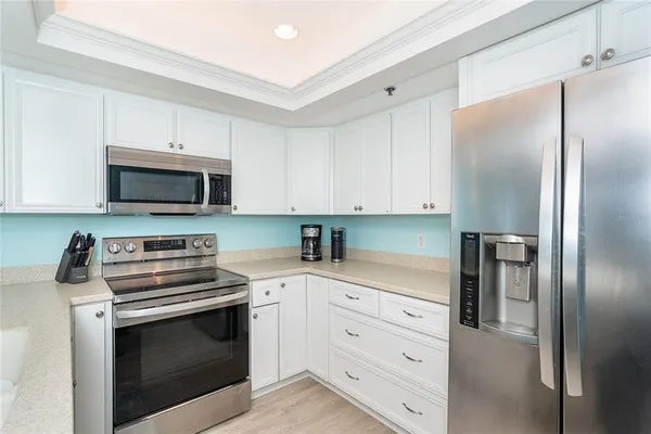 a kitchen with white cabinets and stainless steel appliances