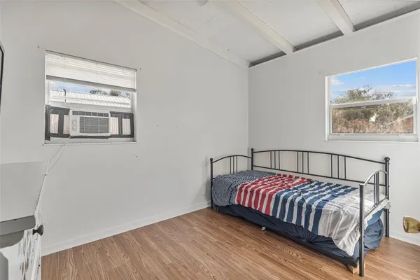 a bedroom with bed and wooden floor