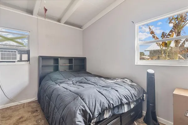 a bed sitting in a bedroom next to a window