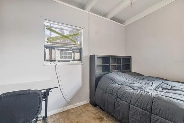 a bed sitting in a bedroom next to a window