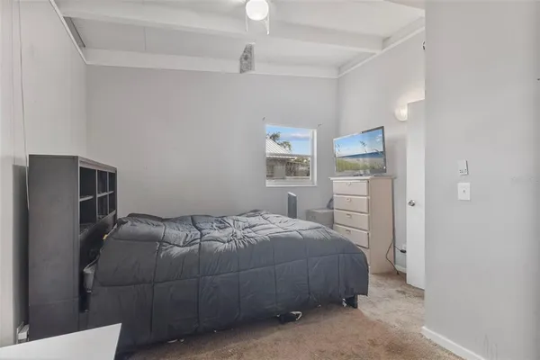 a bedroom with a bed and a refrigerator
