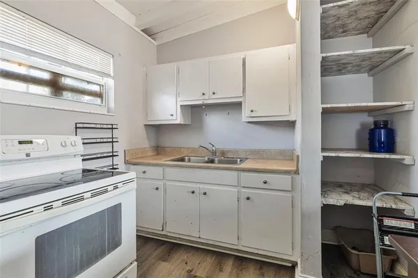 a kitchen with cabinets appliances and a window