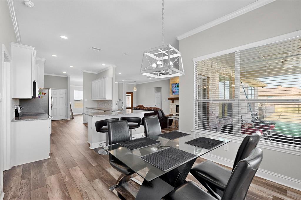 634 Gant Road Sherman, TX 75090 - Photo 17 of 40 Dining area featuring wood-finish flooring, a contemporary chandelier, and a large window with blinds