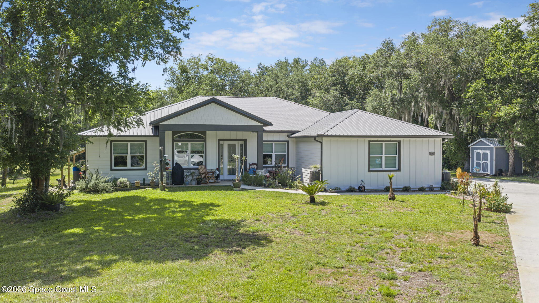 1740 Ford Road Mims, FL 32754 - Photo 1 of 43 a front view of a house with a garden and trees