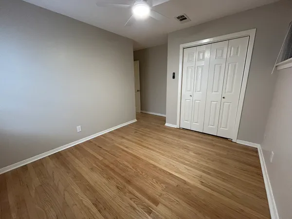 a view of empty room with wooden floor