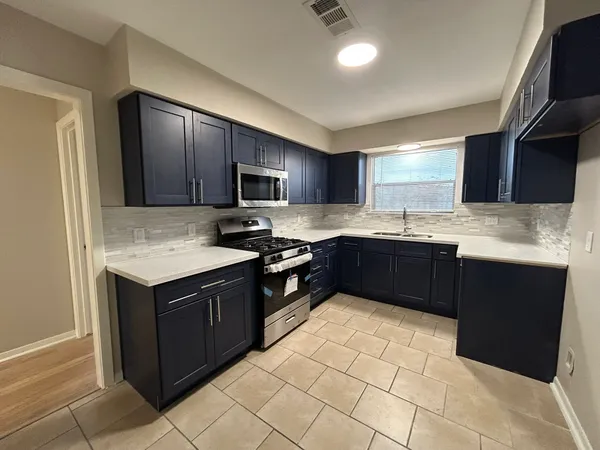 a kitchen with a sink stove top oven and cabinets