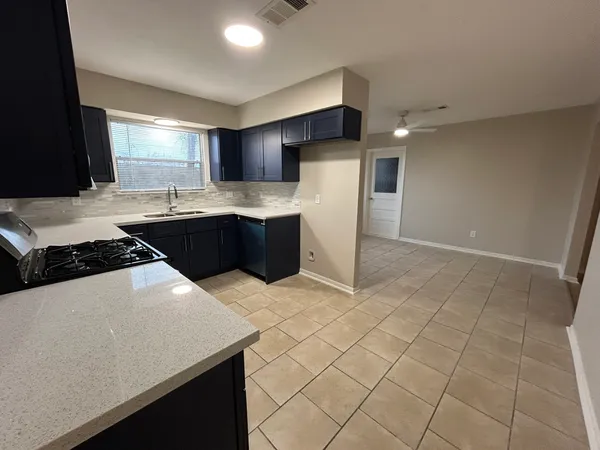 a kitchen with stainless steel appliances a sink a stove a refrigerator and cabinets