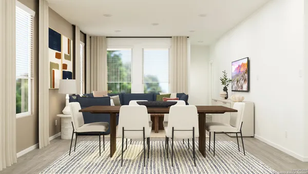 a view of a dining room with furniture a rug and wooden floor