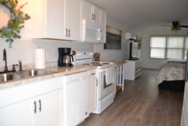 450 Cedar Hill Road Celina, TN 38551 - Photo 36 of 74 a kitchen with stainless steel appliances granite countertop a sink stove and white cabinets with wooden floor