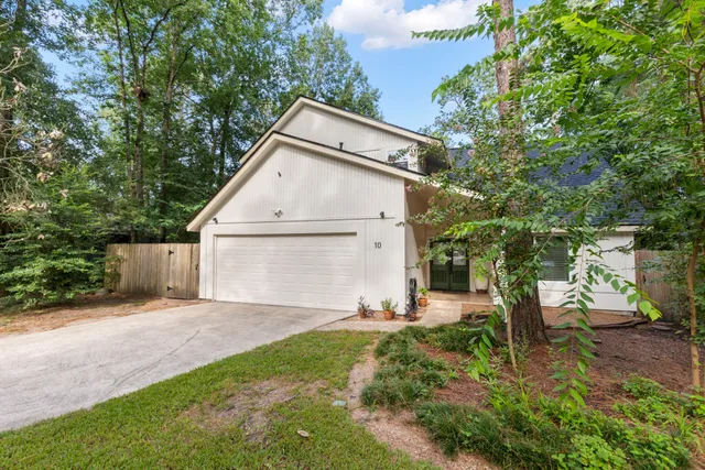 a white house that has a tree in front of it