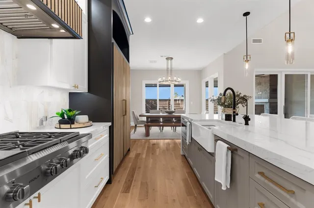 a kitchen with kitchen island a counter space a sink a stove and cabinets
