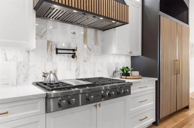 a kitchen with stainless steel appliances granite countertop a stove a refrigerator and a granite counter tops