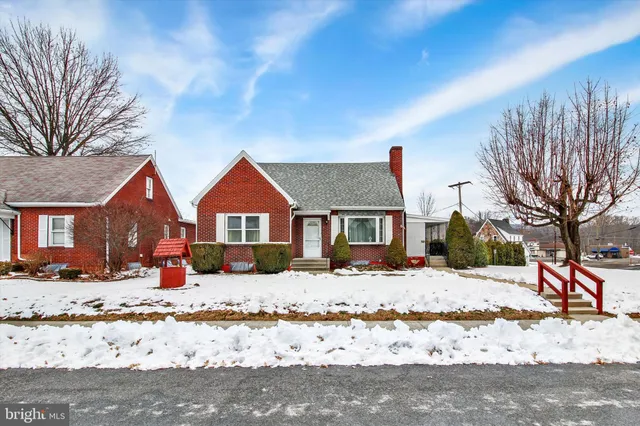 a front view of a house with a yard covered in snow