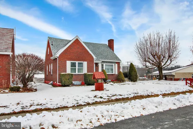 a front view of a house with a yard covered in snow