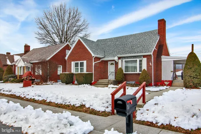 a front view of a house with a yard covered in snow
