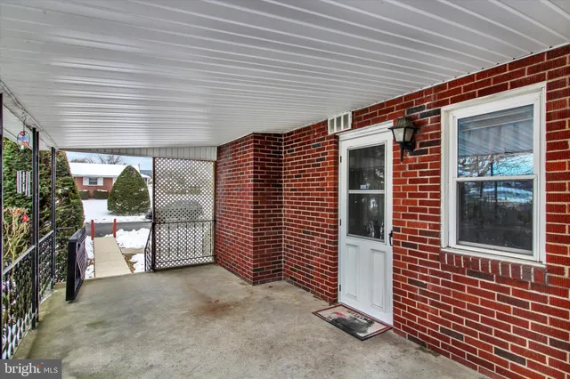 a view of a porch with furniture and floor to ceiling window