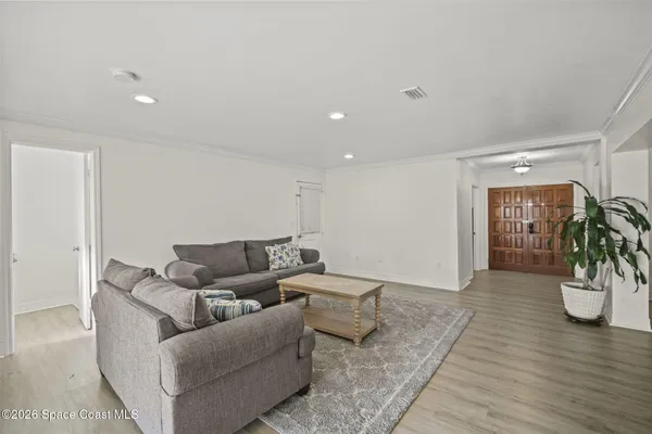a living room with furniture and a wooden floor